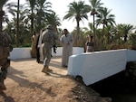A Minnesota National Guard Soldier shakes hands with and official from Bakhan, Iraq on the newly constructed bridge to the village surrounded by canals.