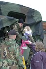 Airmen from the NH Air National Guard's 157th Air Refueling Wing assist Jordan Bell and her mother, Bev, into a five ton during a school evacuation at Nottingham Elementary School, April 16.