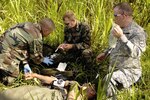 U.S. Air Force Master Sgt. Claude Weidow, left, administers intravenous fluids to South Dakota Army National Guard Spc. Jared Haak, Huron, with the help of Army Sgt. Doug Magee (center), Springfield, and Spc. Jesse Clay, Huron, during a medical evacuation exercise at the school construction site in La Calera, Nicaragua, during New Horizons-Nicaragua 2007, April 6, 2007. The exercise is a $7.25 million joint U.S. and Nicaraguan military humanitarian and training exercise, providing a new school, a medical clinic with free health and veterinary care, and giving aid and strengthening bonds between the two nations. Weidow is a combat medic for the 99th Expeditionary Medical Squadron, Nellis Air Force Base, Nev., and Haak, Magee and Clay are from the 153rd Engineering Battalion, South Dakota Army National Guard, deployed with the 820th Red Horse Squadron, Nellis AFB, Nev. (U.S. Air Force photo by ) (Released)