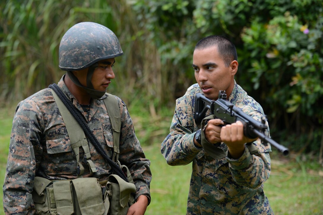 Marine Corps Sergeant Oscar Lopez, Southern Partnership Station Marine detachment,  demonstrates how to properly hold a Galil rifle to a member of the Guatemalan 2nd Brigade Infantry as part of  SPS 2013. The SPS is a 4th Fleet initiative designed to strengthen civil and maritime capabilities with regional partner nations in the Caribbean and Central and South America. (U.S. Air Force photo by Staff Sgt. Ashley Hyatt/Released)