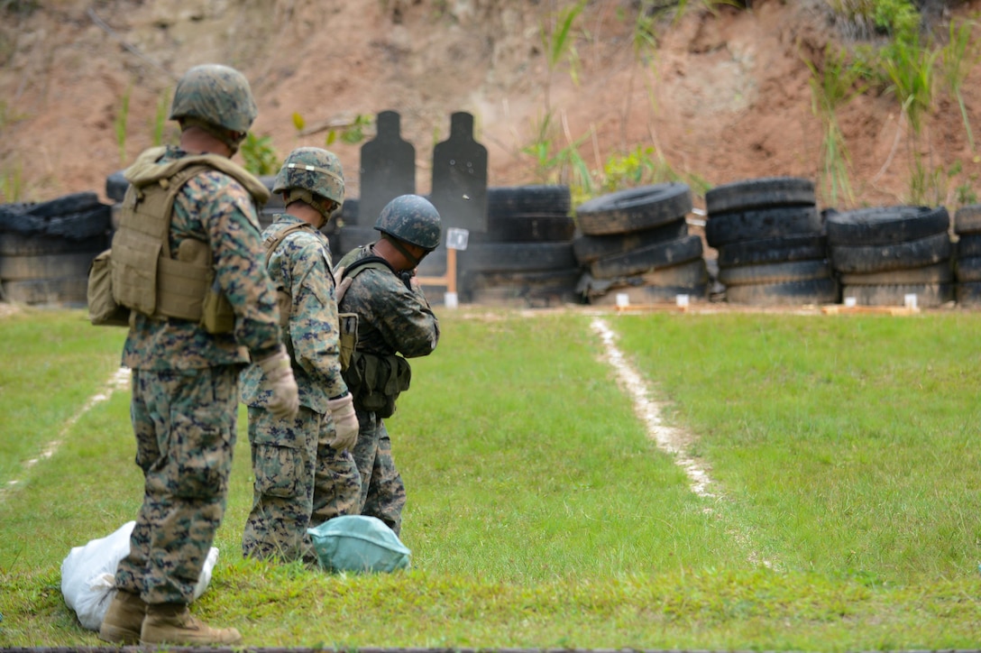 Marine Staff Sgt. Salvador Zuniga (left) and Sgt. Oscar Lopez, Southern Partnership Station Marine detachment, assist a member of the Guatemalan 2nd Brigade Infantry on how to shoot a Galil rifle while moving as part of  SPS 2013. The SPS is a 4th Fleet initiative designed to strengthen civil and maritime capabilities with regional partner nations in the Caribbean and Central and South America. (U.S. Air Force photo by Staff Sgt. Ashley Hyatt/Released)