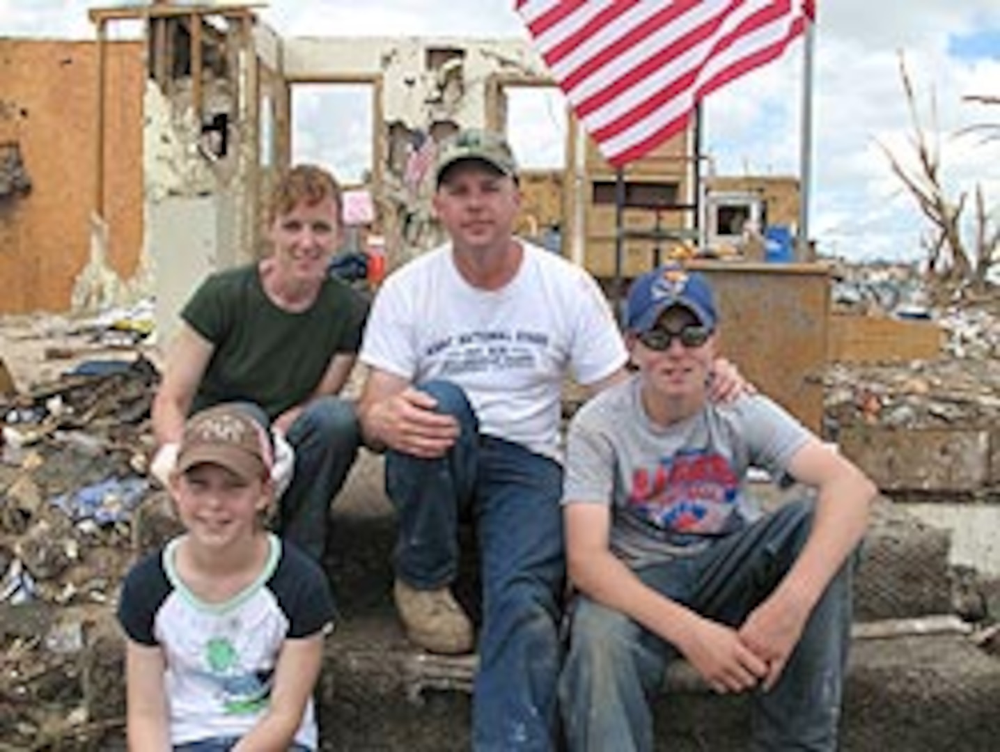 Laura and Rodney Prosser with their daughter Heidi, 11, and son Keith, 13, sit in front of what remains of their Greensburg, Kan., home after it was destroyed by a category F5E tornado, May 4, 2007.