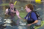 Wisconsin Army National Guard Sgt. Darrell "J.R." Salzman, 27, an Infantryman who lost part of his right arm after the detonation of an explosive device near Baghdad, Iraq, on Dec. 19, 2006, learns to scuba dive from volunteer instructor John W. Thompson, a former National Guardsman, in the Soldiers Undertaking Scuba Diving (SUDS) program at Walter Reed Army Medical Center on June 7, 2007.