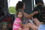 A girl and her mother prepare to be evacuated aboard a Texas Army National Guard UH-60 Blackhawk helicopter from flooded areas in Burnet County, Texas, June 28, 2007. Some 13,000-14,000 square miles of Texas were flooded by torrential rains, leading Texas Governor Rick Perry to mobilize the Texas National Guard in support of civil rescue and recovery efforts.