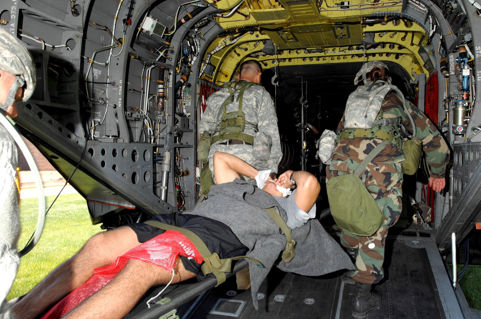 Members of Company B, 109th Area Medical Support Battalion, Rapid City, SD, load a victim of simulated chemical bombing onto a CH-47 Chinook helicopter at Black Hills State University, Spearfish, SD, during Operation Yellow Jacket, as part of the Joint Thunder 2007 annual training exercise.