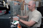 Army National Guard Sgt. Morley Wagner determines which one of numerous circuit cards and multiple transducers is failing in an automated flight control system at Camp Arifjan, Kuwait, on July 4, 2007. Wagner is a member of Task Force AVCRAD (Aviation Classification Repair Activity Depot), which maintains components from Army National Guard, Regular Army and Army Reserve helicopters flying missions in Afghanistan and Iraq.