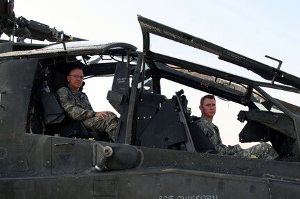 Chief Warrant Officer-4 Kevin Purtee (left) and Chief Warrant Officer-2 Allen Crist, Company B, 1st Battalion, 149th Aviation Regiment (Attack), man the AH-64 helicopter they used to help save the life of a critically wounded Soldier.