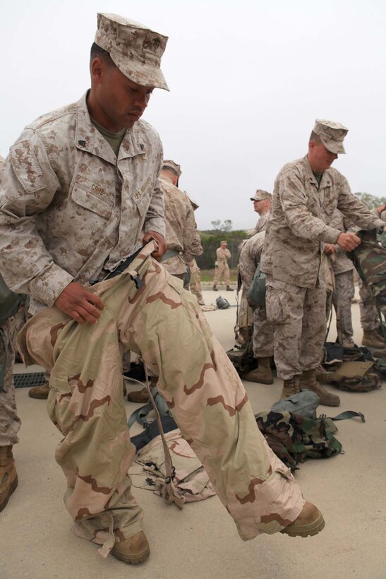 Marines with I Marine Expeditionary Force, put on Mission Oriented Protective Posture suits before entering a gas chamber at Camp Pendleton, Calif., March 26. The MOPP suit protects Marines from chemical and biological contaminants and protects their skin from contact with chemical agents.