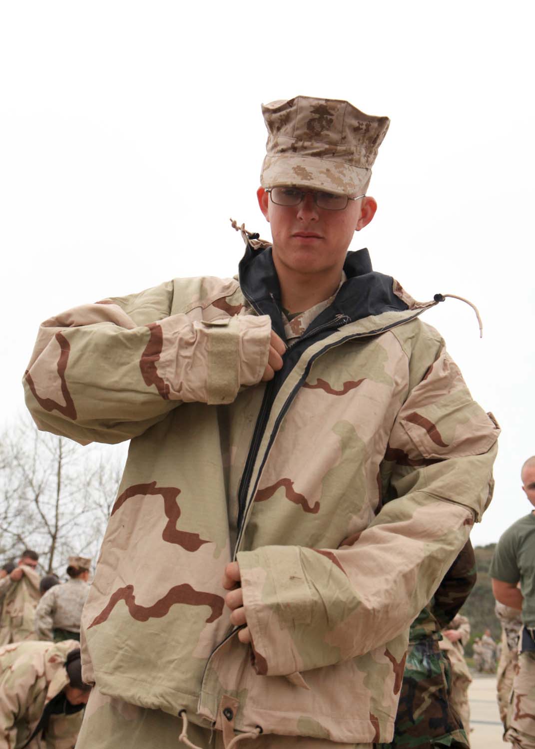 Lance Cpl. Seth Littau, a food service specialist with I Marine Expeditionary Force Headquarters Group, zips up a Mission Oriented Protective Posture suit during gas chamber training at Camp Pendleton, Calif., March 26. The gas chamber is required annual training for Marines, which provides Marines with a basic knowledge of how to don and clear a mask to effectively defend against chemical or biological assaults.