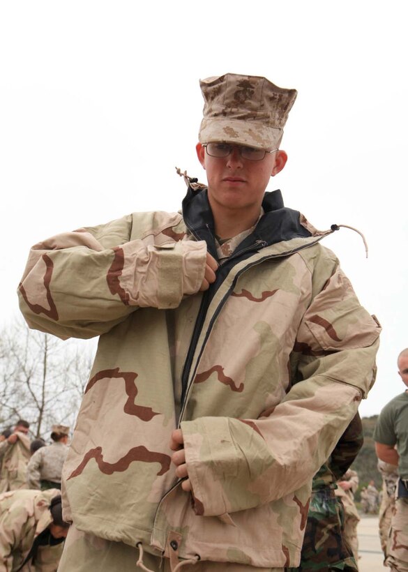 Lance Cpl. Seth Littau, a food service specialist with I Marine Expeditionary Force Headquarters Group, zips up a Mission Oriented Protective Posture suit during gas chamber training at Camp Pendleton, Calif., March 26. The gas chamber is required annual training for Marines, which provides Marines with a basic knowledge of how to don and clear a mask to effectively defend against chemical or biological assaults.