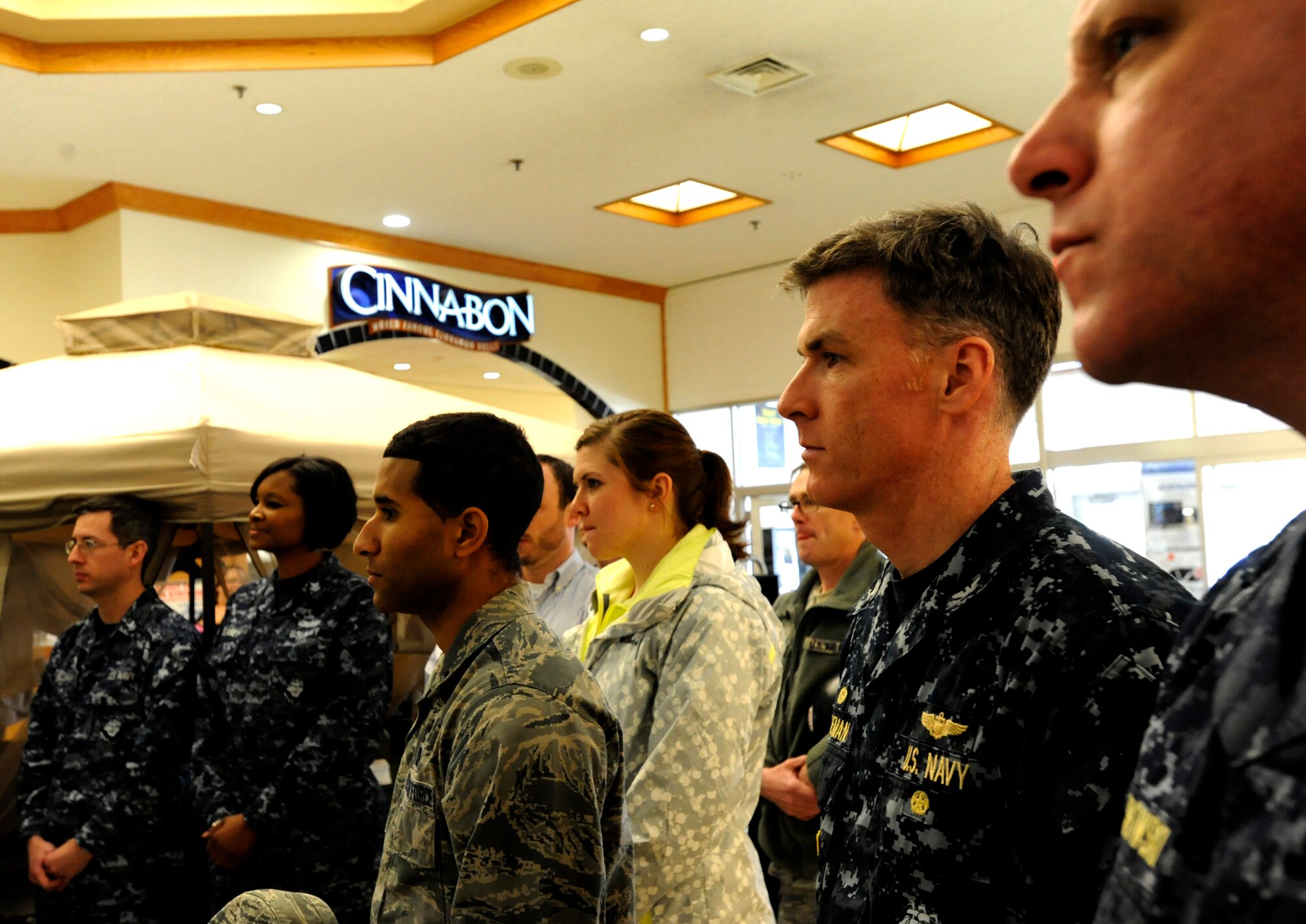 A mixture of U.S. Navy, Air Force members and civilians listen to a speech during the Sexual Assault Awareness Month campaign cake cutting ceremony in The Exchange foyer at Misawa Air Base, Japan, April 1, 2013. According to the Defense Department, this month’s theme is “Hurts one. Affects all.” (U. S. Air Force photo by Airman 1st Class Kenna Jackson)
