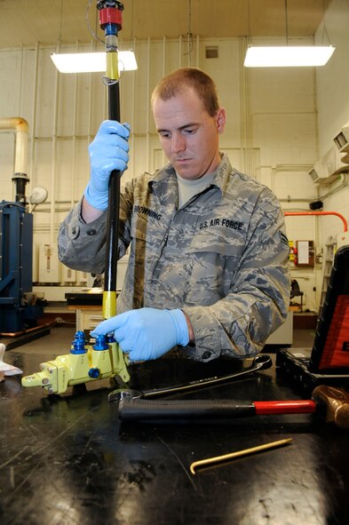 Airman 1st Class Andrew Browning, 2nd Maintenance Squadron Accessories Flight Hydraulics, attaches a hydraulic line to a sliding sleeve assembly prior to a test run on Barksdale Air Force Base, La., April 1. Once a part has finished being inspected and repaired, it is run through a hydraulic test stand which simulates the conditions the part goes through while in flight, before it is sent back to the flightline. (U.S. Air Force photo/Airman 1st Class Andrew Moua)