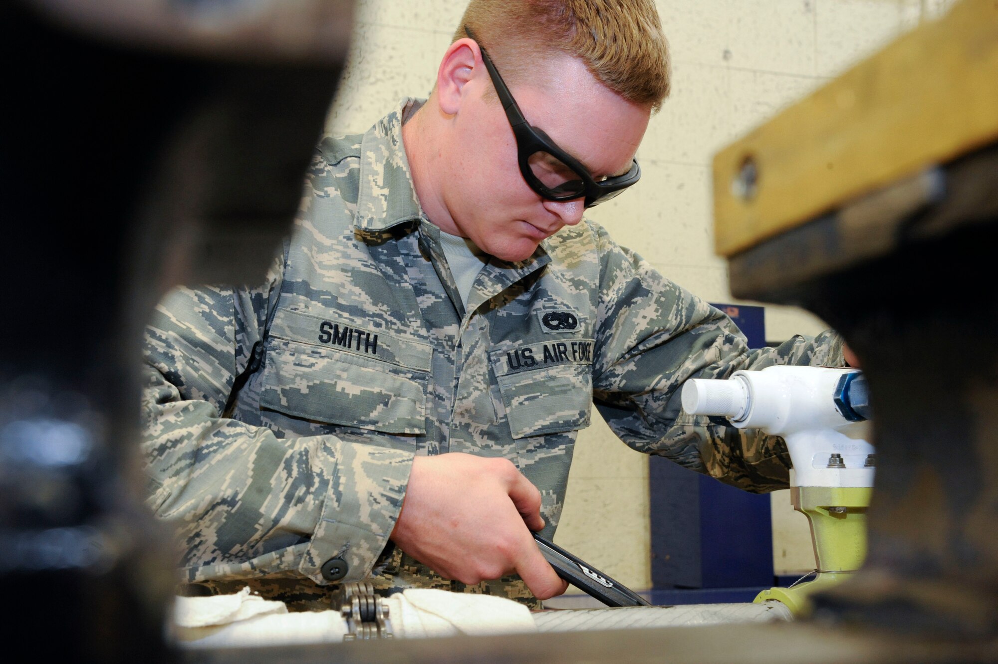 Senior Airman Jeremy Smith, 2nd Maintenance Squadron Accessories Flight Hydraulics, applies safety wiring to a bomb door actuator on Barksdale Air Force Base, La., April 1. Safety wiring helps secure the end cap on the actuator and prevents it from coming loose during flight. (U.S. Air Force photo/Airman 1st Class Andrew Moua)