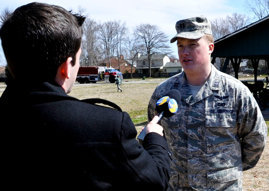 U.S. Air Force Capt. Kevin Whitlatch, Air Combat Command public affairs, conducts an interview with a local television news station during an F-22 Raptor crash exercise involving the city of Hampton, Va., and Langley Air Force Base, March 28, 2013. The exercise allowed emergency responders from Hampton and Langley to work together and solidify their plan if such an event should occur. (U.S. Air Force photo by Staff Sgt. Wesley Farnsworth/Released)