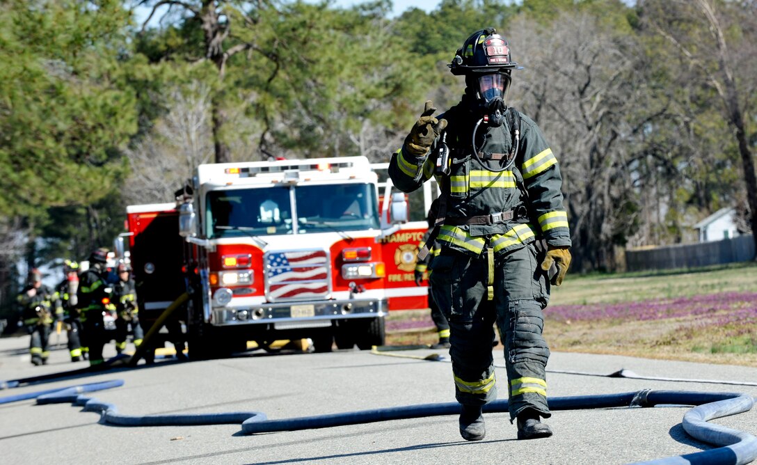 A firefighter with the city of Hampton Fire and Rescue signals back to his truck during an F-22 Raptor crash exercise conducted by the city of Hampton, Va., and Langley Air Force Base, March 28, 2013. The exercise allowed emergency responders from Hampton and Langley to work together and solidify their plan if such an event should occur. (U.S. Air Force photo by Staff Sgt. Wesley Farnsworth/Released)