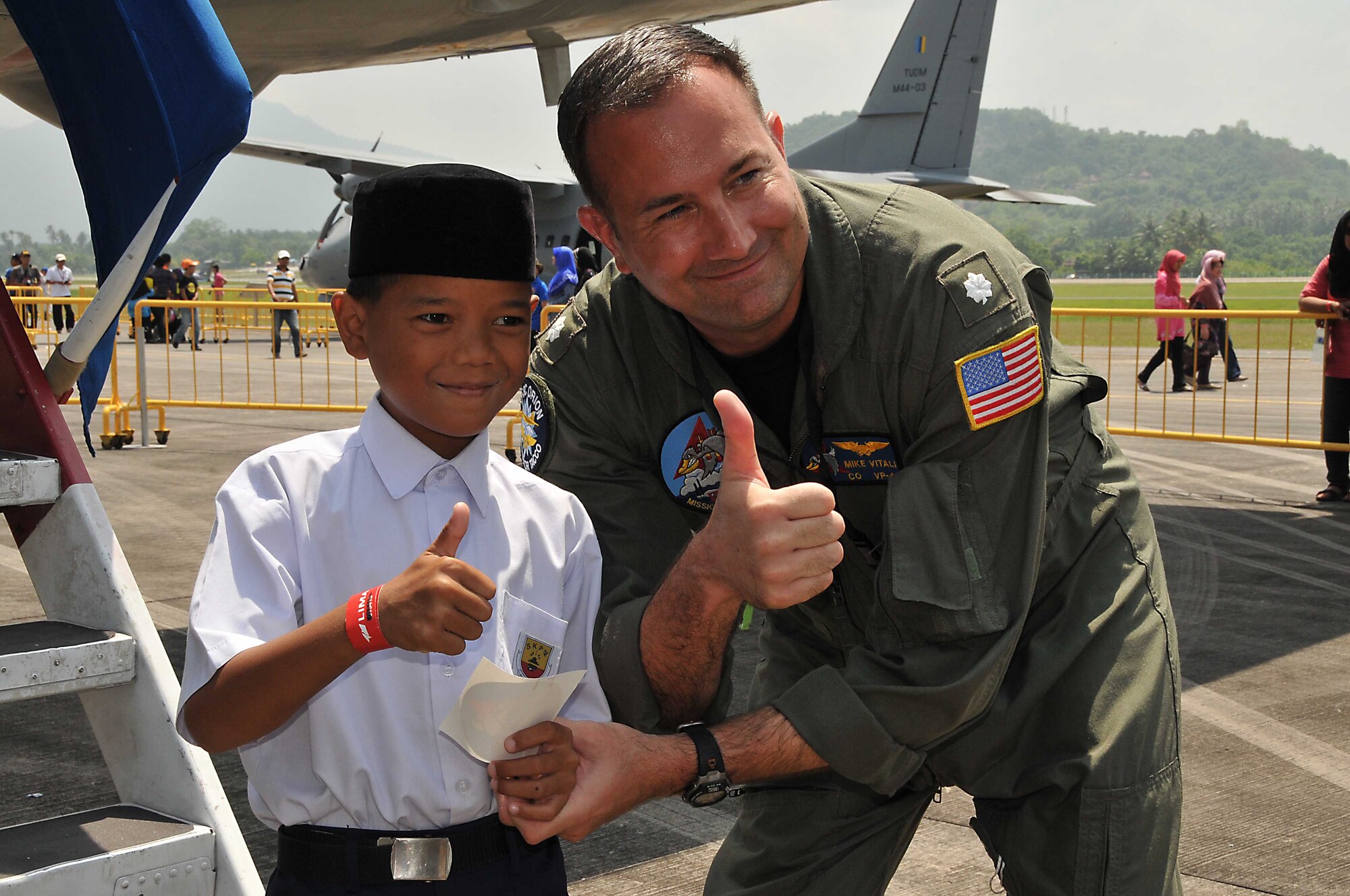 U.S. Navy Cmdr. Michael Vitali, Commanding Officer of Patrol Squadron 45, gives a thumbs up with a young boy from the Rumah Nur Kasih Langkawi Orphanage March 29, 2013, during the 2013 Langkawi International Maritime and Aerospace Exhibition (LIMA 13) at Langkawi, Malaysia.  The photo was taken following a tour on a P3-C Orion aircraft; fifty children from the local Malaysian orphanage were given a distinguished visitor tour of Navy and Air Force aircraft during the LIMA 13. The event provides a forum to showcase U.S. and foreign assets while forming relationships that ultimately contribute to friendships and increased interoperability with navies of other countries.  (U.S. Navy photo/Mass Communication Specialist 1st Class Michelle Lucht)  