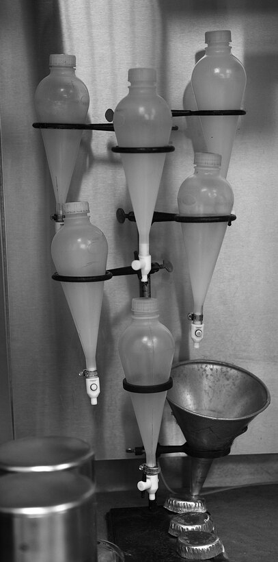 Separatory funnels are used to test the percentage by volume of fuel system icing inhibitor (FSSI) in the water once separated from the fuel. All fuel must be sampled to ensure that it is clean, pure and dry before being approved for use in jets. (U.S. Air Force photo by Senior Airman Brittany Paerschke-O’Brien/Released)