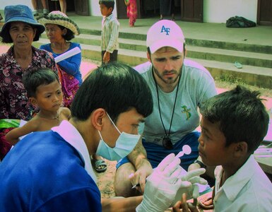 1st Lt. Joey Brewer, 16th Airlift Squadron pilot from Joint Base Charleston assists a medical doctor during a two-week trip to Cambodia, March 1 – 15, 2013, in support of Vets with a Mission, a not-for-profit agency that conducts humanitarian missions in Vietnam and Cambodia. (Courtesy photo)