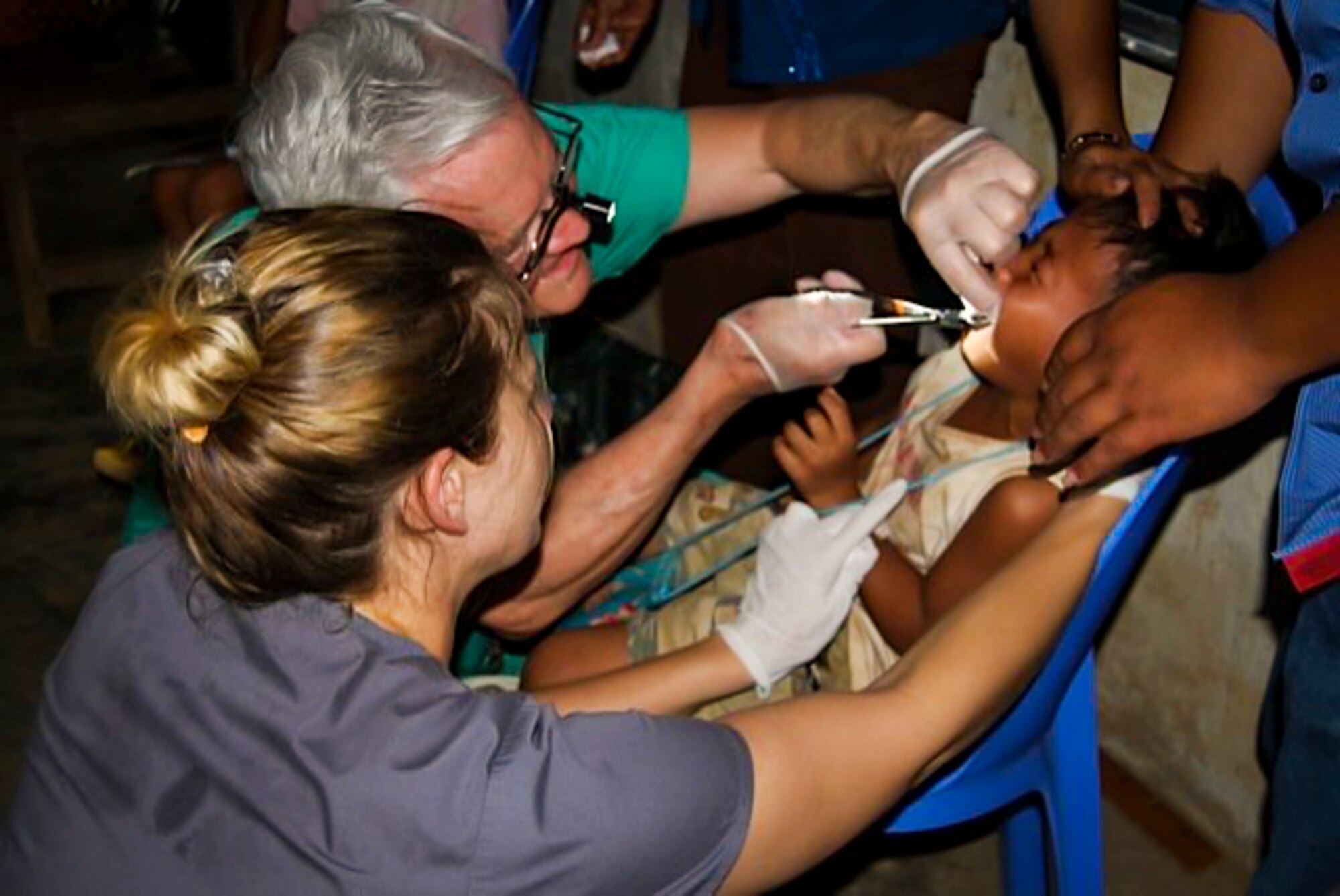 Tori Brewer, spouse of 1st Lt. Joey Brewer, an oral surgery assistant from Daniel Island, S.C., assists oral surgeon Dr. Tom Love, Vets with a Mission Dental coordinator, with a dental procedure during a two-week trip to Cambodia, March 1 – 15, 2013, in support of VAWM, a not-for-profit agency that conducts humanitarian missions in Vietnam and Cambodia. (Courtesy photo)