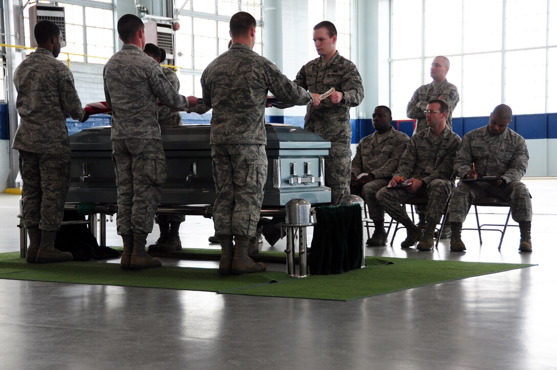 Members of the Maxwell-Gunter Base Honor Guard demonstrate a funeral service ceremony during the montly honor guard competition in the Honor Guard Hanger, March 26. During the monthly competition the different flights are evaluated by members of base leadership on how well they execute different ceremonial procedures. (U.S. Air Force photo by Master Sgt. Michael Voss) 