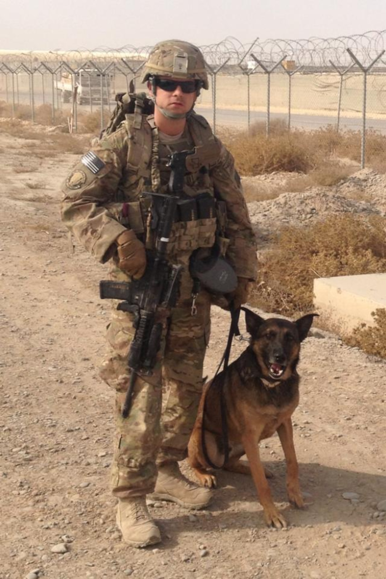 Tech. Sgt. Todd Shumate and his military working dog, Jack, both deployed from Tyndall's 325th Security Forces Squadron, pose for a picture down range. Sergeant Shumate and Jack form a team that through training saves lives. (Courtesy photo)
