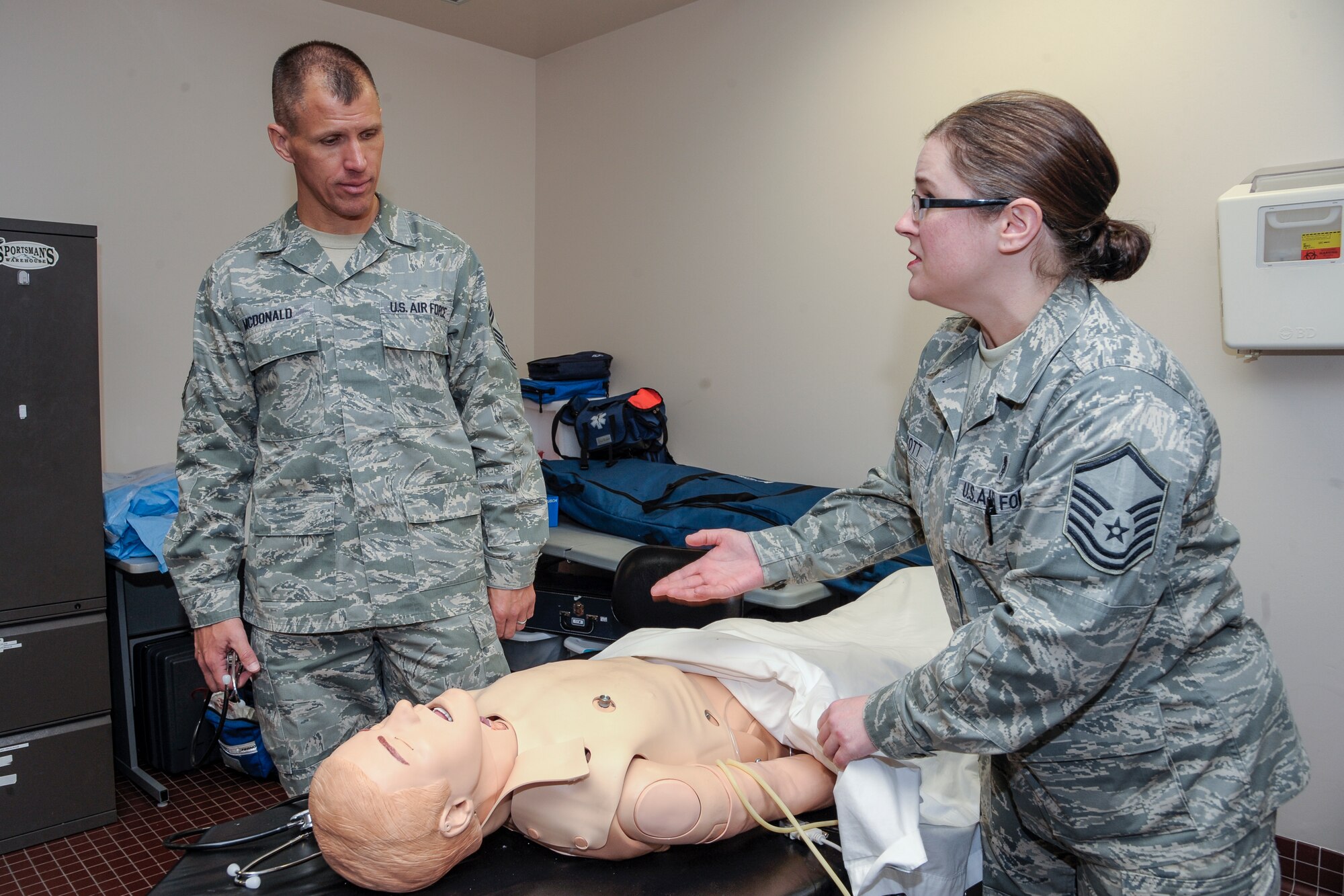 Chief Master Sgt. Steve McDonald, Pacific Air Forces command chief master sergeant, and Master Sgt. Katherine Scott, 354th Medical Operations Squadron education training NCO in charge, examine a Simulation Man March 21, 2013, Eielson Air Force Base, Alaska. Scott explained the versatility and importance of using the SIM Man for in-house life support training.  (U.S. Air Force Photo/Airman 1st Class Peter Reft)