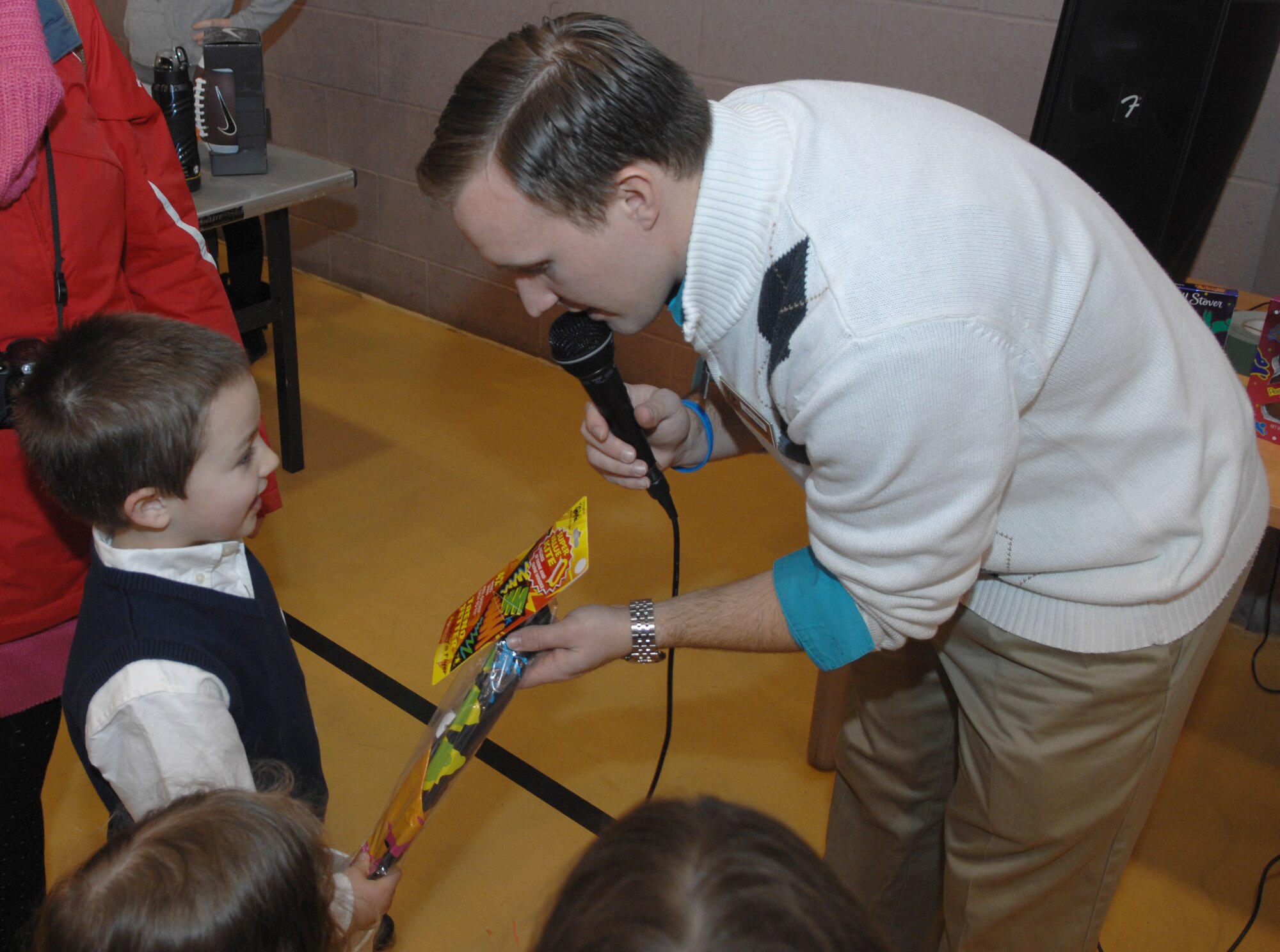 Mathew Kuhl, 100th Force Support Squadron programs coordinator, hands a Team Mildenhall child a kite after the child won it during an Easter egg hunt March 30, 2013, at the RAF Mildenhall Youth Programs center, England. Children hunted for eggs, some of which contained special tickets that could be redeemed for prizes. (U.S. Air Force photo by Airman 1st Class Dillon Johnston/Released)