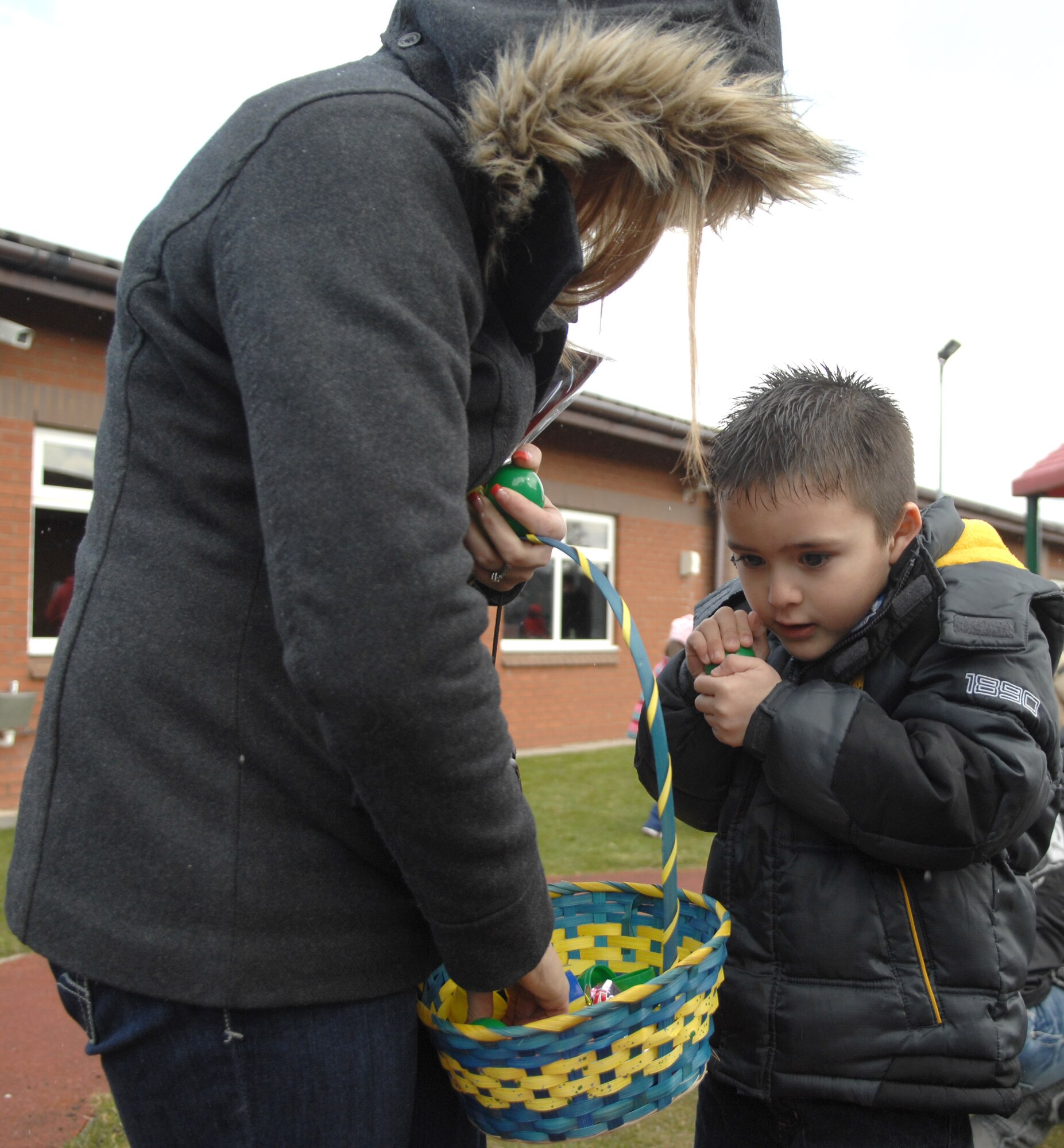 A Team Mildenhall child opens a plastic egg following an Easter egg hunt March 30, 2013, at the RAF Mildenhall Youth Programs center, England.  The eggs contained a variety of prizes including toys, candy and special prize tickets. (U.S. Air Force photo by Airman 1st Class Dillon Johnston/Released)