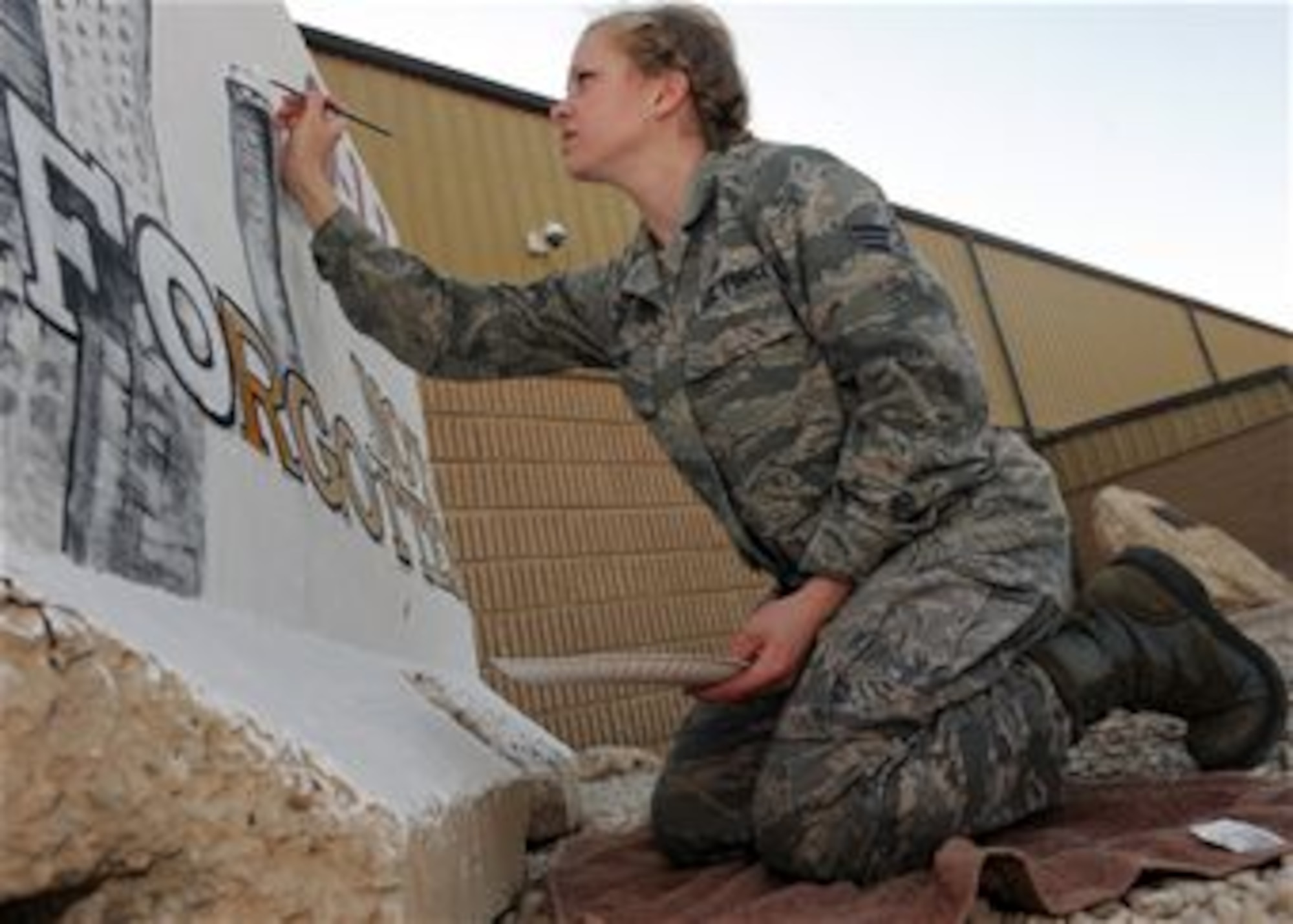 Senior Airman Adrianna Recine, 379th Expeditionary Medical Group laboratory technician, volunteers her time to refurbish the installation’s 9/11 barrier memorial, March 21. Recine said she volunteered to paint the 9/11 wall to show those who sacrificed their lives were not forgotten. Recine is deployed from the 633rd Medical Support Squadron at Joint Base Langley-Eustis, Va. (U.S. Air Force photo by Senior Airman Joel Mease/Released)