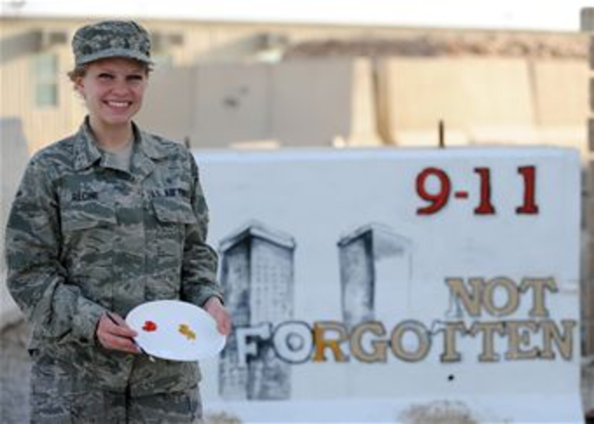 Senior Airman Adrianna Recine, 379th Expeditionary Medical Group laboratory technician, volunteers her time to refurbish the installation’s 9/11 barrier memorial, March 21. Recine said she volunteered to paint the 9/11 wall to show those who sacrificed their lives were not forgotten. Recine is deployed from the 633rd Medical Support Squadron at Joint Base Langley-Eustis, Va. (U.S. Air Force photo by Senior Airman Joel Mease/Released)
