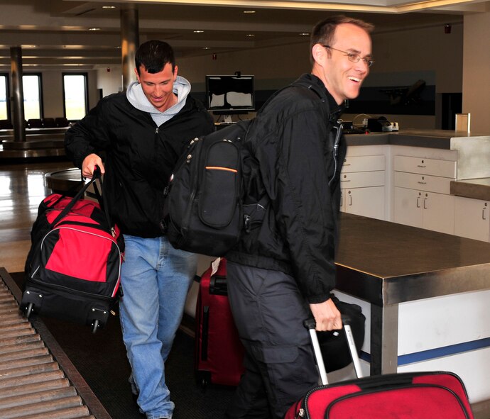 Master Sgt. Dallas Powers, 736th AMXS avionics technician, and Tech. Sgt. Michael Kelly, 736th AMXS electrical environmental systems technician, walk through the passenger terminal with their luggage after passing through customs March 28, 2013, at Dover Air Force Base, Del. Powers and Kelly were part of the first 13 members to return from a deployment to Israel in support of the President of the United States. (U.S. Air Force photo/Tech. Sgt. Chuck Walker)