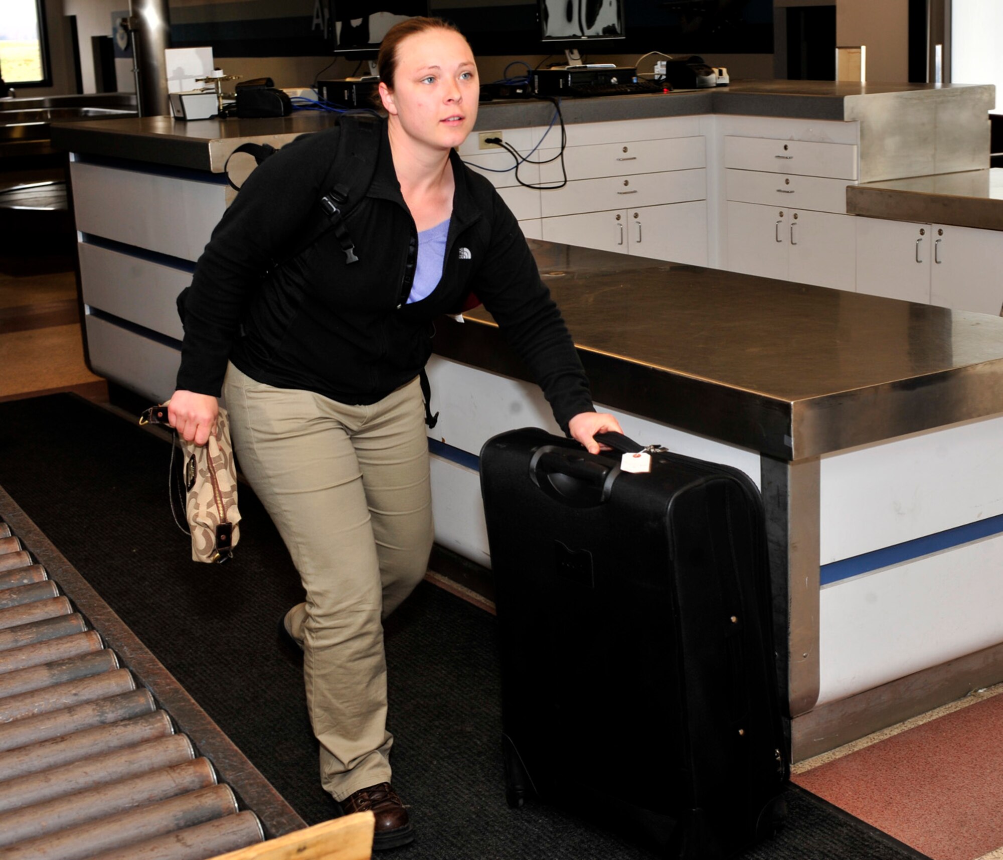 Staff Sgt. Brinnae Wigley, 736th AMXS hydraulics specialist, walks with her luggage in the passenger terminal after passing through customs March 28, 2013, at Dover Air Force Base, Del. Wigley was part of the first 13 people to return from a deployment to Israel in support of the President of the United States. (U.S. Air Force photo/Tech. Sgt. Chuck Walker)