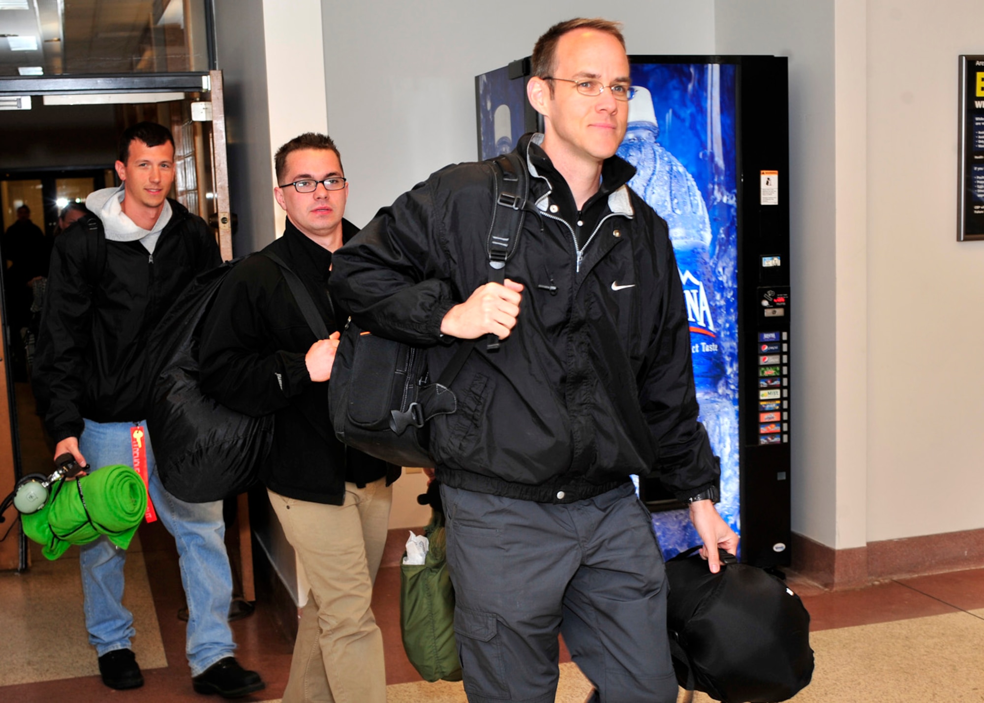 Master Sgt. Dallas Powers, 736th Aircraft Maintenance Squadron avionics technician, Tech. Sgt. Michael Kelly, 736th AMXS electrical environmental systems technician, and Staff Sgt. John Guthrey, 736th AMXS jet engine mechanic, walk through the passenger terminal March 28, 2013, at Dover Air Force Base, Del. Powers, Kelly, and Guthrey were part of the first 13 members to return from a deployment to Israel in support of the President of the United States. (U.S. Air Force photo/Tech. Sgt. Chuck Walker)