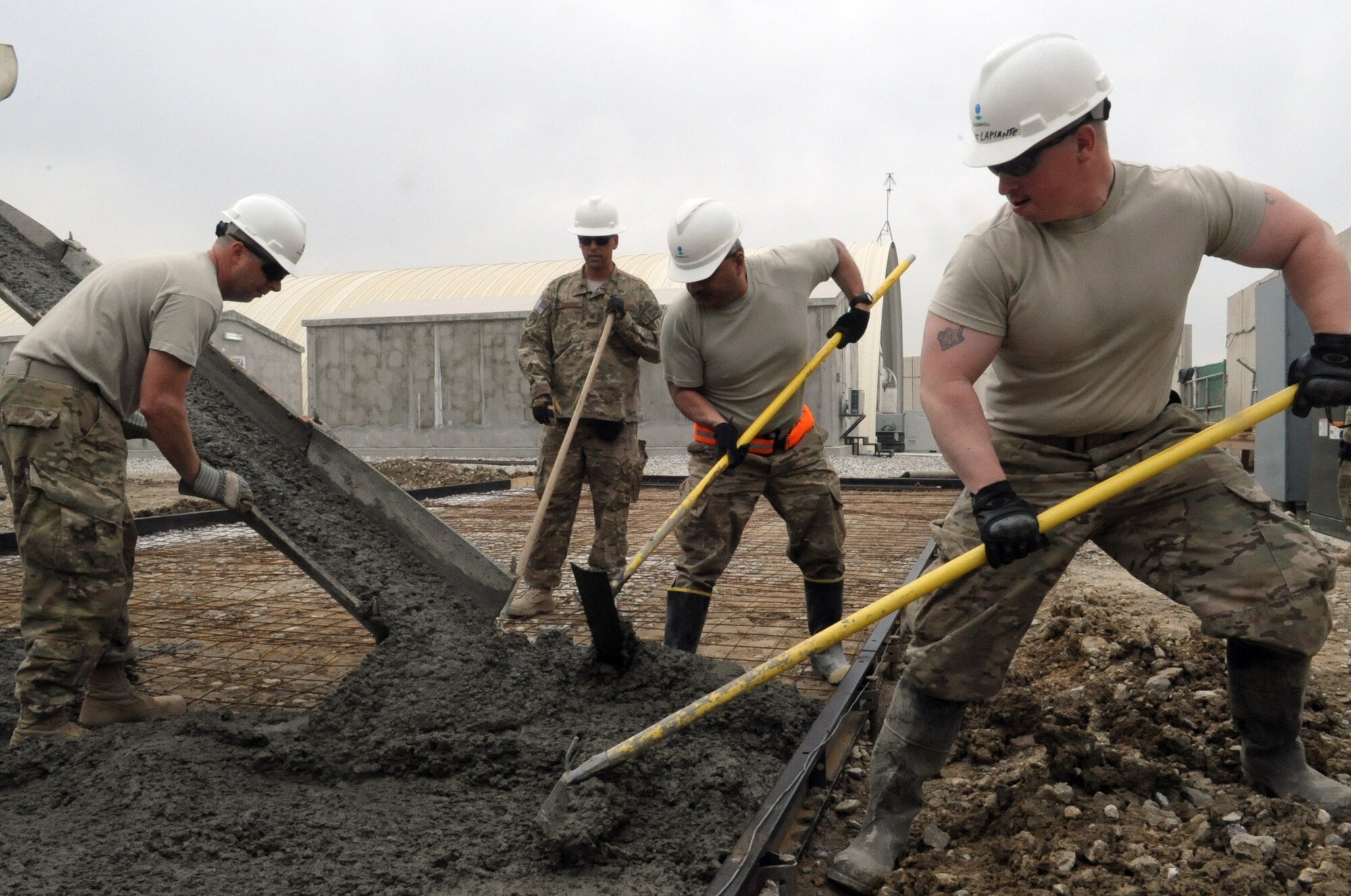 Members of the 455th Expeditionary Civil Engineer Squadron spread concrete during a project on Bagram Airfield, Afghanistan, March 27, 2013. The "Dirt Boyz" have poured 83.5 cubic meters of concrete for 11 separate sites in the past three months. (U.S. Air Force photo/Staff Sgt. David Dobrydney)