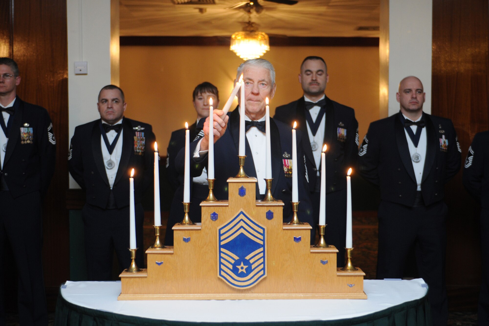 RAF LAKENHEATH, United Kingdom – Retired Chief Master Sgt. of the Air Force Robert Gaylor lights the Chief's candle during the Chief Master Sergeant Recognition Ceremony held at Eagles' Landing March 9. The rank of chief master sergeant represents the top one percent of the enlisted force. (U.S. Air Force photo by Airman 1st Class Dana J. Butler)