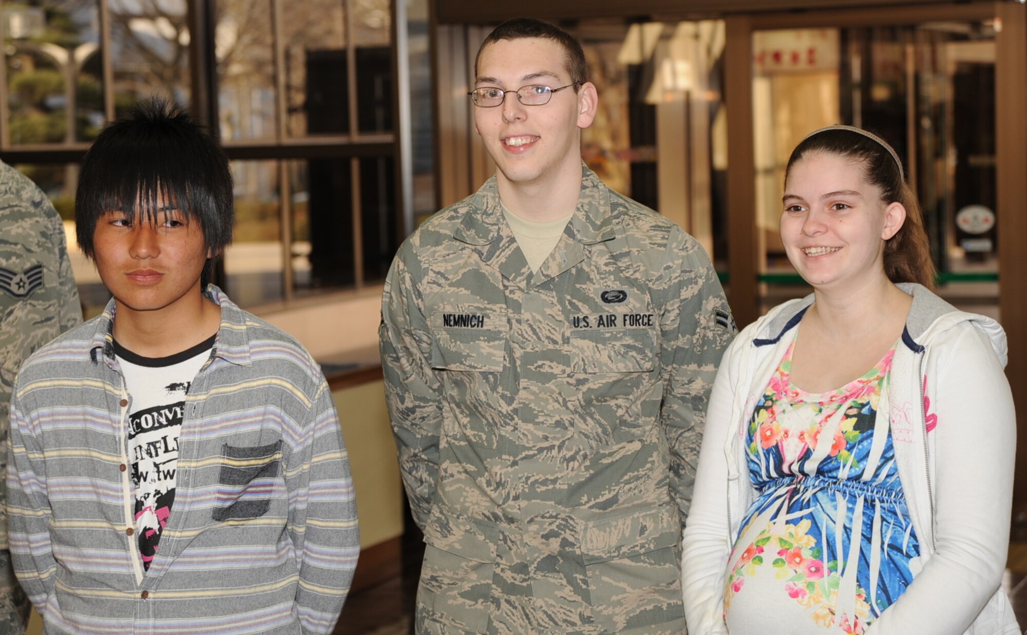 Ryuu Sasaki, left, student from Taro Daiichi Junior High School, Miyako City, Japan, stands with host family U.S. Air Force Airmen 1st Class Steven and Merideth Nemnich, 35th Force Support Squadron, during a Homestay introduction ceremony at the Misawa City Civic Center, Misawa, Japan, March 29, 2013.  Sasaki was one of 11 students from the recovering area where earthquakes and tsunamis hit in 2011 to visit and stay the weekend with an Air Force family at Misawa Air Base. (U.S. Air Force photo by Senior Airman Derek VanHorn)
