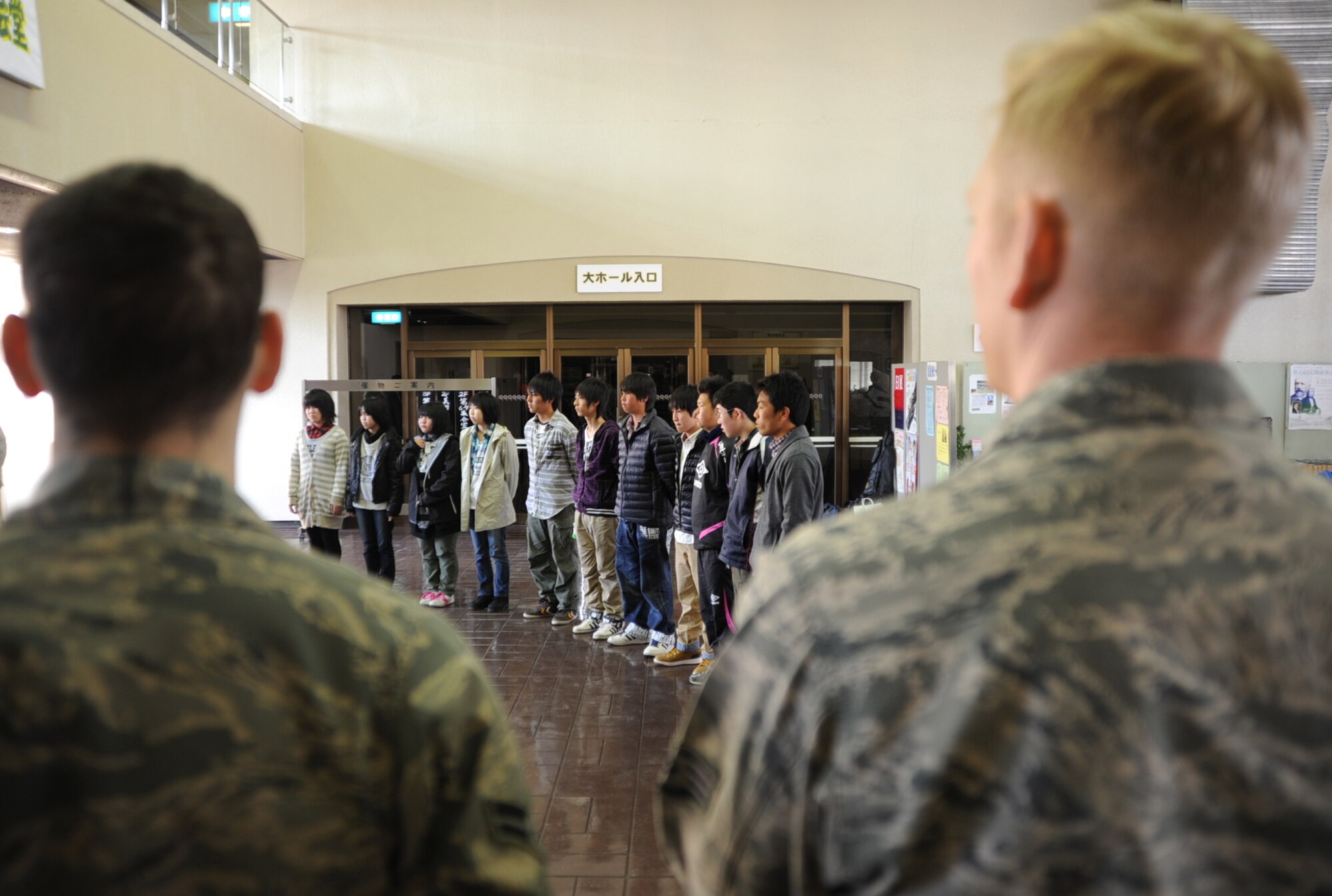 U.S. Air Force Airman 1st Class Steven Nemnich, left, 35th Force Support Squadron, and Staff Sgt. Eric Janes, 35th Civil Engineer Squadron, wait to meet their weekend guests at the Misawa City Civic Center before a weekend Homestay event at Misawa Air Base in Misawa, Japan, March 29, 2013. Nemnich and Janes were two of six Air Force families who hosted 11 Japanese students from Taro Daiichi Junior High School, Miyako City, Japan, in an effort to share cultural traditions and demonstrate continued U.S. support to a community that endured severe natural disasters two years ago. (U.S. Air Force photo by Senior Airman Derek VanHorn)