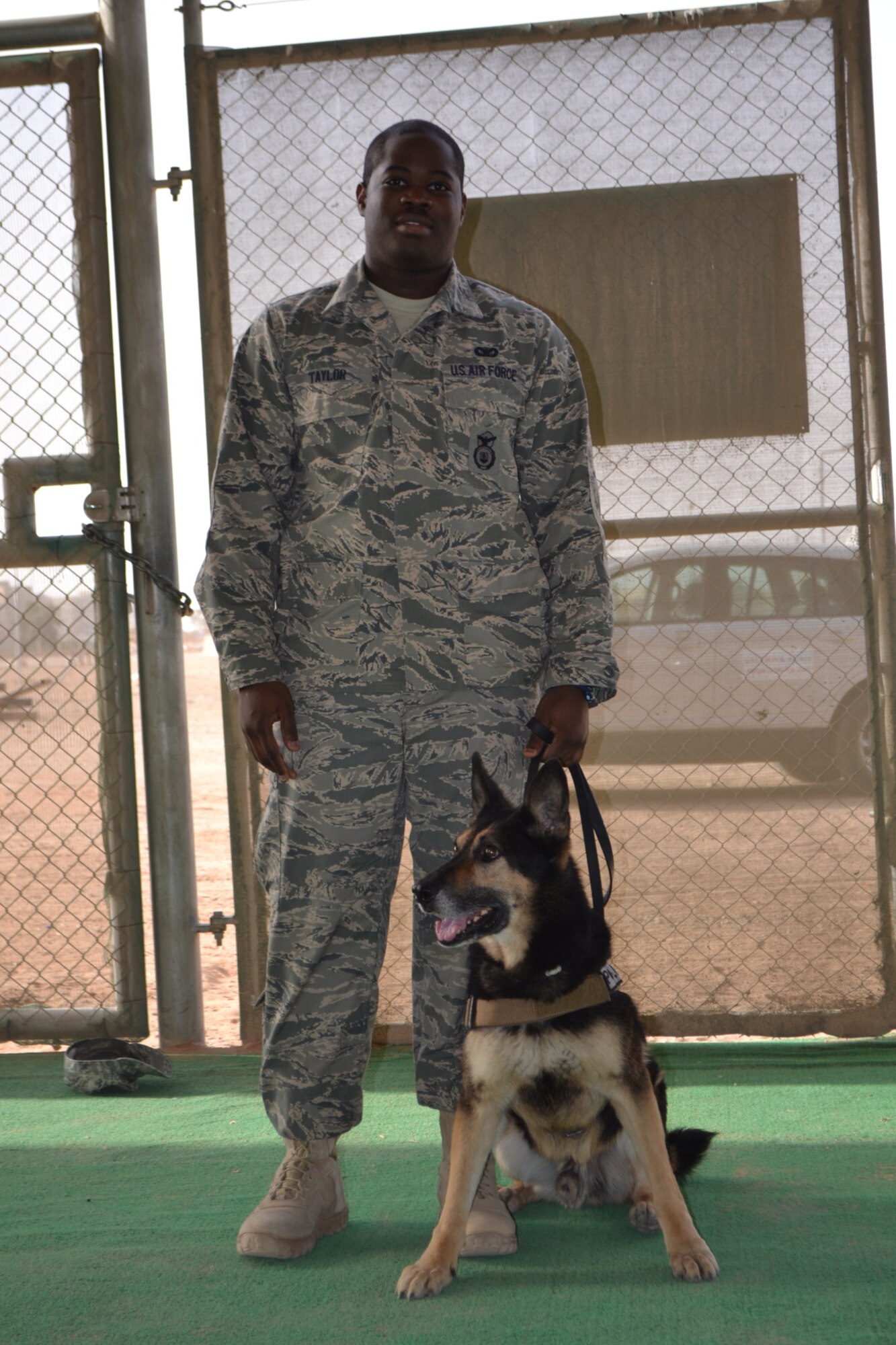 Senior Airman Rayshawn Taylor, 64th Expeditionary Security Forces Squadron, is a military working dog handler. He is teamed with Charlie, a K-9 who has deployed seven times and was wounded in combat on a previous deployment in Afghanistan. (Air Force photo/Staff Sgt. Cynthia Brockes)