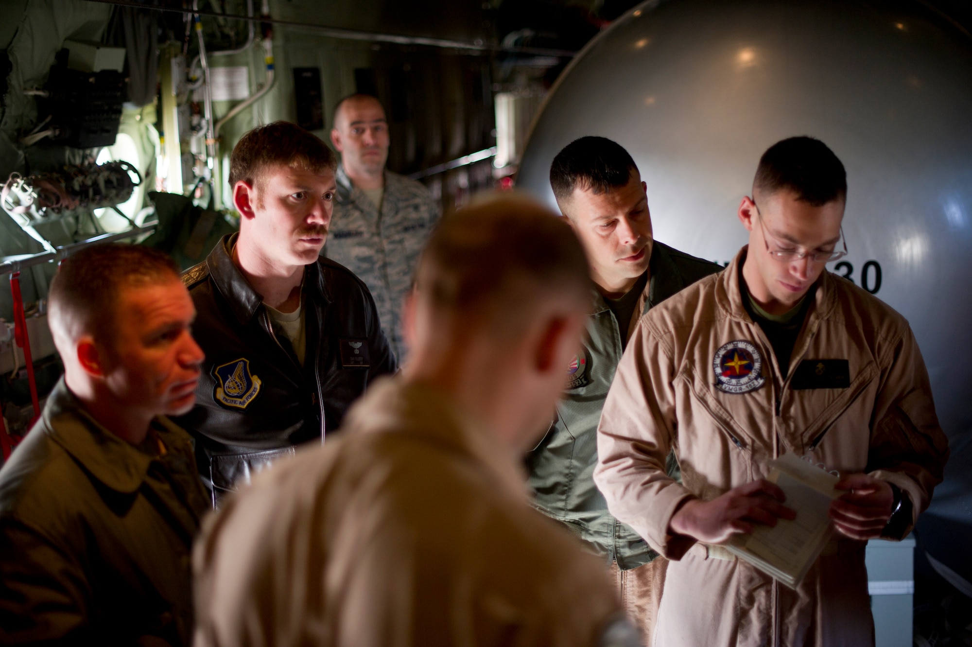 YOKOTA AIR BASE, Japan -- Capt. Dan Pallister, Pilot with the 36th Airlift Squadron receives a pre-flight briefing before takeoff March 26, 2013, at Yokota Air Base, Japan. Marines with the Marine Aerial Refueler Transport Squadron 152th Training Squadron, 1st Marine Aircraft Wing, Iwakuni, Japan, worked alongside members of the 36th AS, doing controlled airspace training. Pallister is required to be on the flight as an aircrew member that has flown to the location previously. Ultimately, the goal is to get an initial cadre qualified on the training so they can qualify the rest of their crews. (U.S. Air Force photo by Staff Sgt. Stacy Moless)