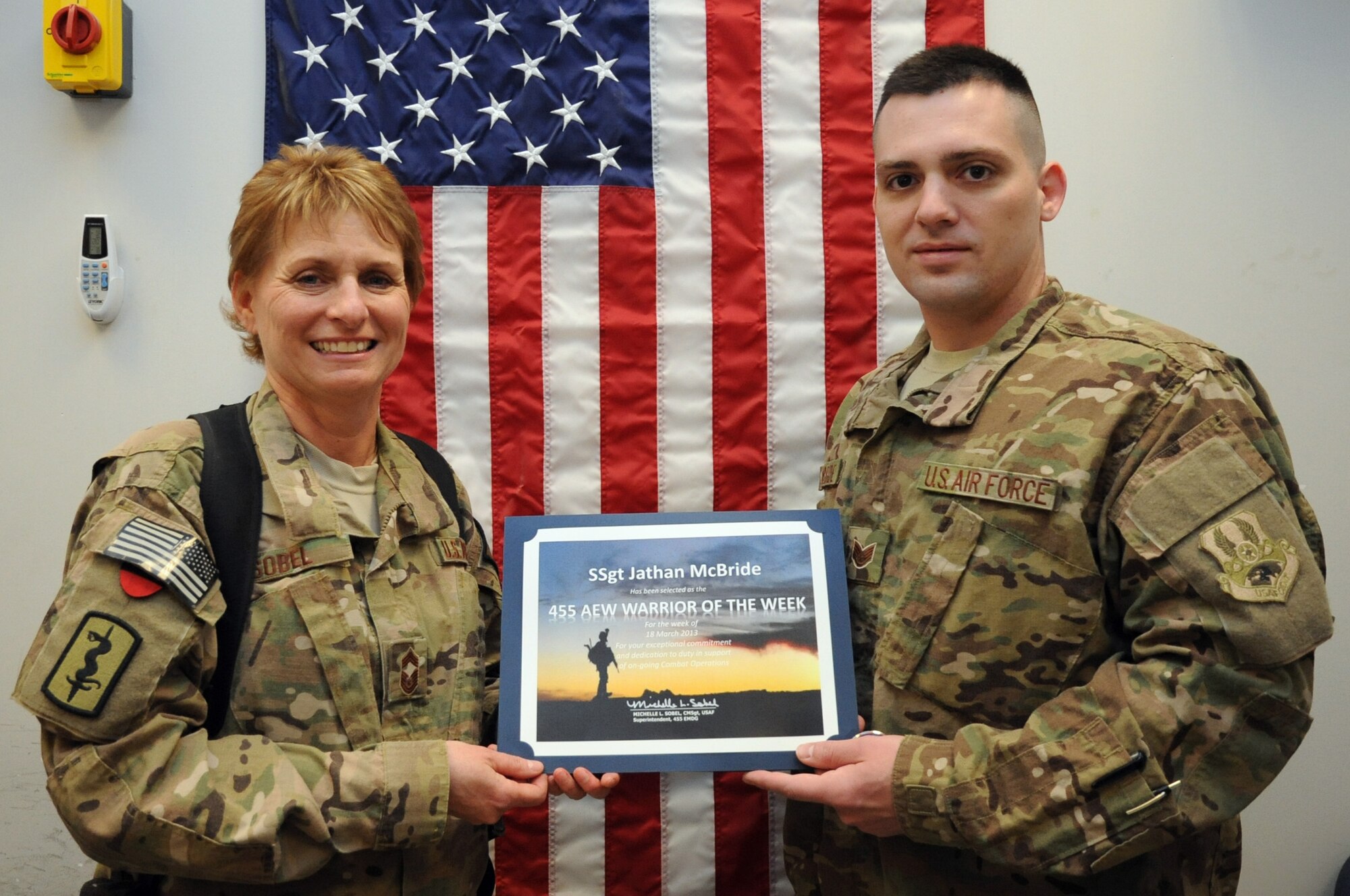 Chief Master Sgt. Michelle Sobel, 455th Expeditionary Medical Group superintendent, presents the "Warrior of the Week" award to Staff Sgt. Jathan McBride, 41st Expeditionary Electronic Combat Squadron intelligence operations analyst, on Bagram Airfield, Afghanistan, March 27, 2013. McBride has provided more than 50 intelligence briefs in support of 70 EC-130H Compass Call missions. (U.S. Air Force photo/Staff Sgt. David Dobrydney)