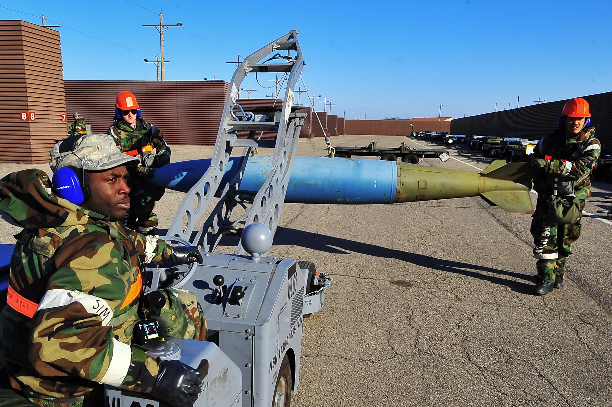 Senior Airman Danny Churches (left), Airman 1st Class Dennis Morton (driver), and Airman 1st Class Francisco Amutan, 51st Munitions Squadron flight line maintenance crew members, load a 2,000-pound bomb onto a munitions trailer for transportation to the flight line during Operational Readiness Exercise Beverly Midnight 13-02 at Osan Air Base, Republic of Korea, March 20, 2013.  The aircraft munitions maintenance organization is responsible for maintaining Osan’s munitions stockpile. (U.S.  Air Force photo/Staff Sgt. Emerson Nuñez)