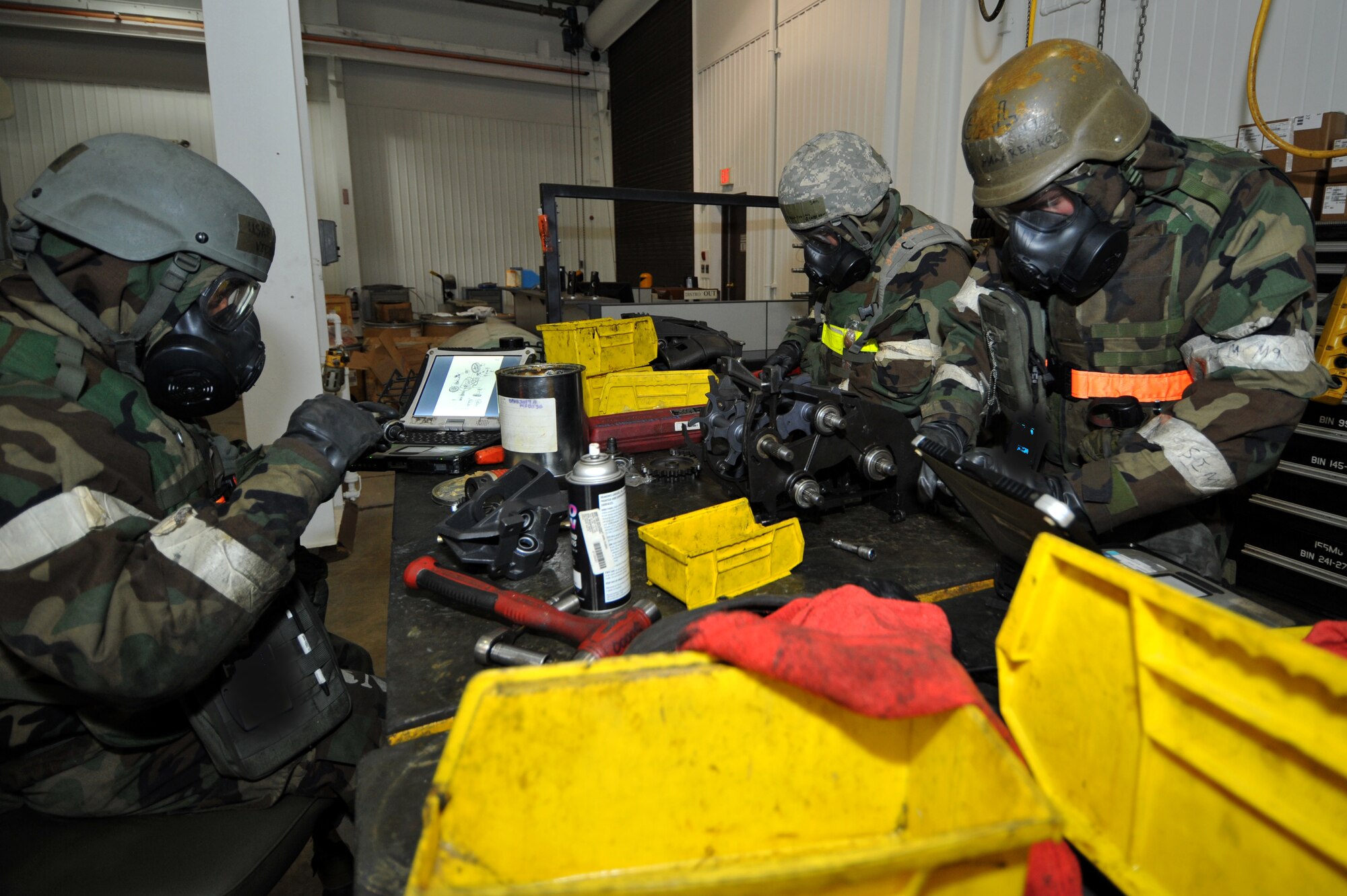 Airman 1st Class Victor Leon (left), Airman 1st Class Philip Makarenko (right), and Senior Airman Vladimir Shanshivy, 51st Munitions Squadron armament technicians, put together the entrance unit of a drum assembly for a 30-millimeter mini-gun during Operational Readiness Exercise Beverly Midnight 13-02 at Osan Air Base, Republic of Korea, March 20, 2013.  Armament technicians have a variety of responsibilities and can perform tasks in full mission oriented protective posture gear.   (U.S.  Air Force photo/Staff Sgt. Emerson Nuñez)