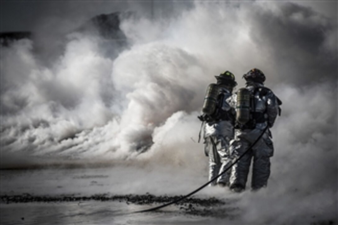 U.S. Air Force firefighters extinguish a fire during a fire training exercise at Mountain Home Air Force Base, Idaho, on March 4, 2013.  Two teams of firefighters from the 366th Civil Engineer Squadron worked in unison to push the fire back without it reigniting behind them.  The training exercise was one component of a base-wide operational readiness exercise.  