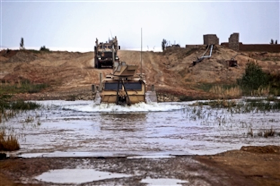 U.S. Marines drive their tactical vehicles through a river to Camp Dwyer after conducting a mission on Forward Operating Base Geronimo in Afghanistan's Helmand province, March 28, 2013. 