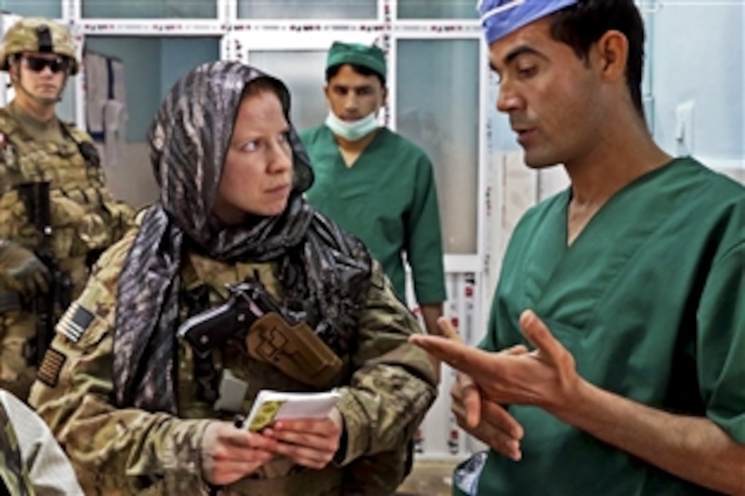 U.S. Navy Lt. j.g. Laura Cook, left, talks with Ahmad Jawid Ghafoori, hospital anesthesiologist, during a meeting at Farah City Hospital in Afghanistan's Farah province, March 26, 2013. Cook, a physician assistant, is assigned to Provincial Reconstruction Team Farah.