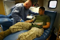John Brown, Armed Services Blood Program nurse sticks Petty Officer 3rd Class Daniel Rivera with a needle so he can give blood aboard Marine Corps Air Station New River, March 25.
