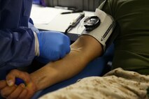 John Brown, Armed Services Blood Program nurse sticks Petty Officer 3rd Class Daniel Rivera with a needle so he can give blood aboard Marine Corps Air Station New River, March 25.