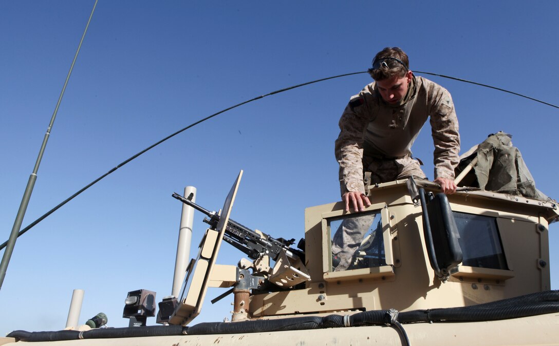 Lance Cpl. Robert Carroll organizes the gun turret of his MRAP in preparation for a mounted patrol through Kajaki, March 30.  Carroll is a member of the Kajaki Police Advisor Team (Photo by Sgt. Bobby J. Yarbrough)