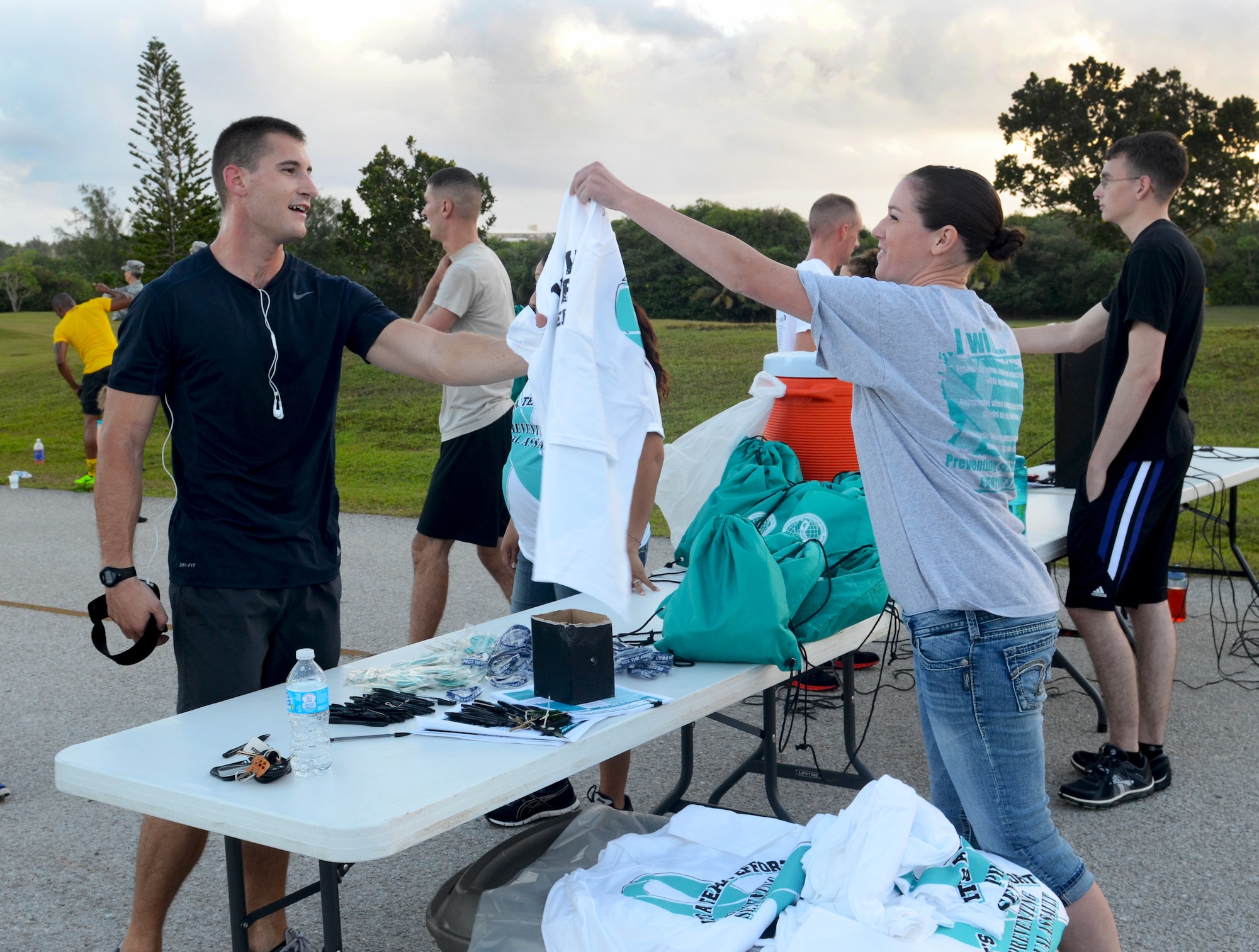 Senior Airman Richard Moore, 36th Combat Communications Squadron client systems journeyman, receives a t-shirt from Senior Airman Jaclyn Scott, 36th Wing Sexual Assault Prevention and Response victim advocate after finishing among the top 50 runners during the Sexual Assault Awareness Month 5K on Andersen Air Force Base, Guam, April 3, 2013. Several units, to include civilians and spouses, joined together to participate in the run to raise awareness in the fight against sexual assault. (U.S. Air Force photo by Senior Airman Benjamin Wiseman/Released)