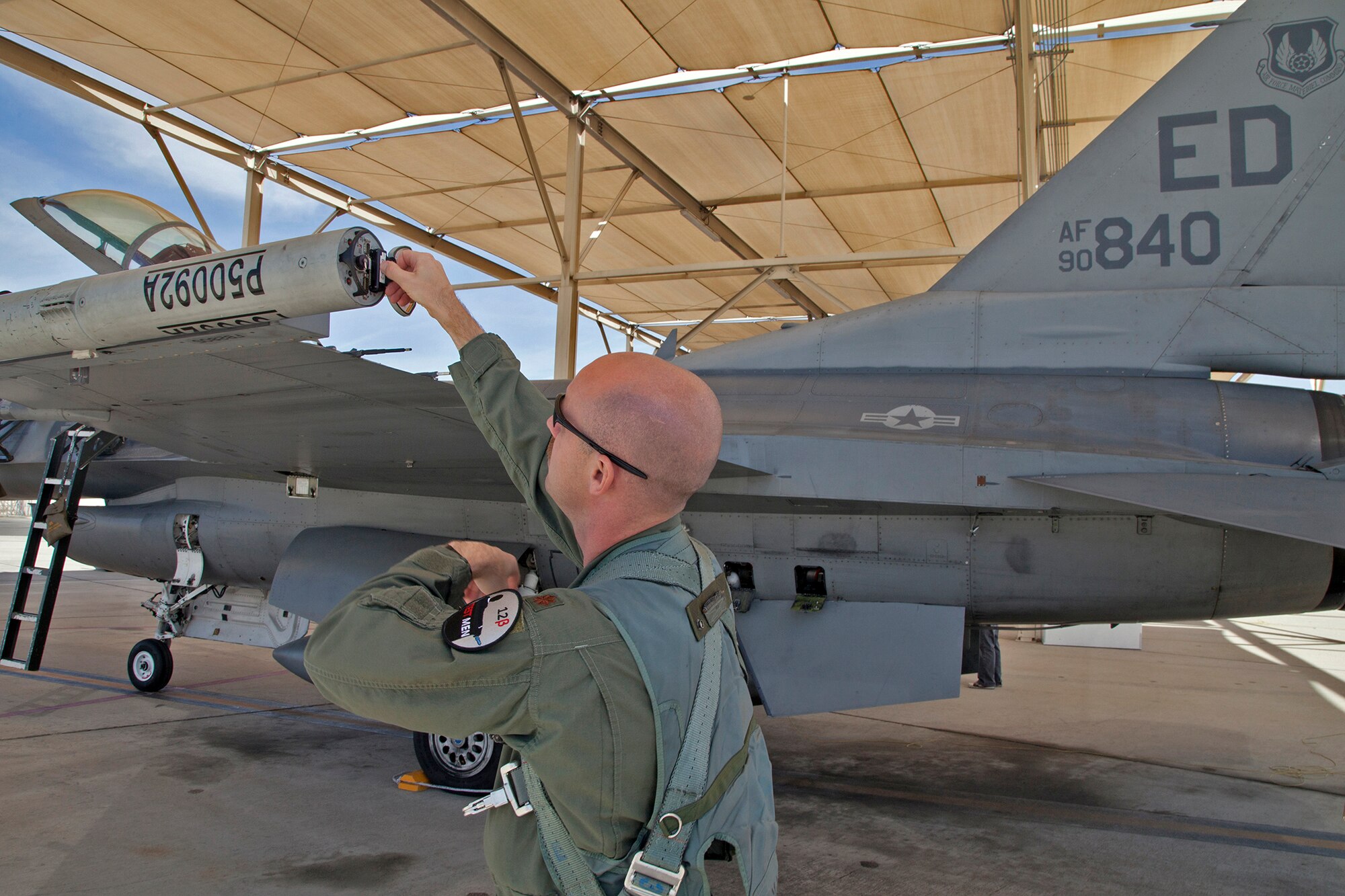 Maj. James Hayes III, HAVE POSIT II project pilot, puts the Automatic Air Collision Avoidance System data cartridge into the P5 Combat Training System pod prior to takeoff March 19. (U.S. Air Force Photo by Christian Turner)